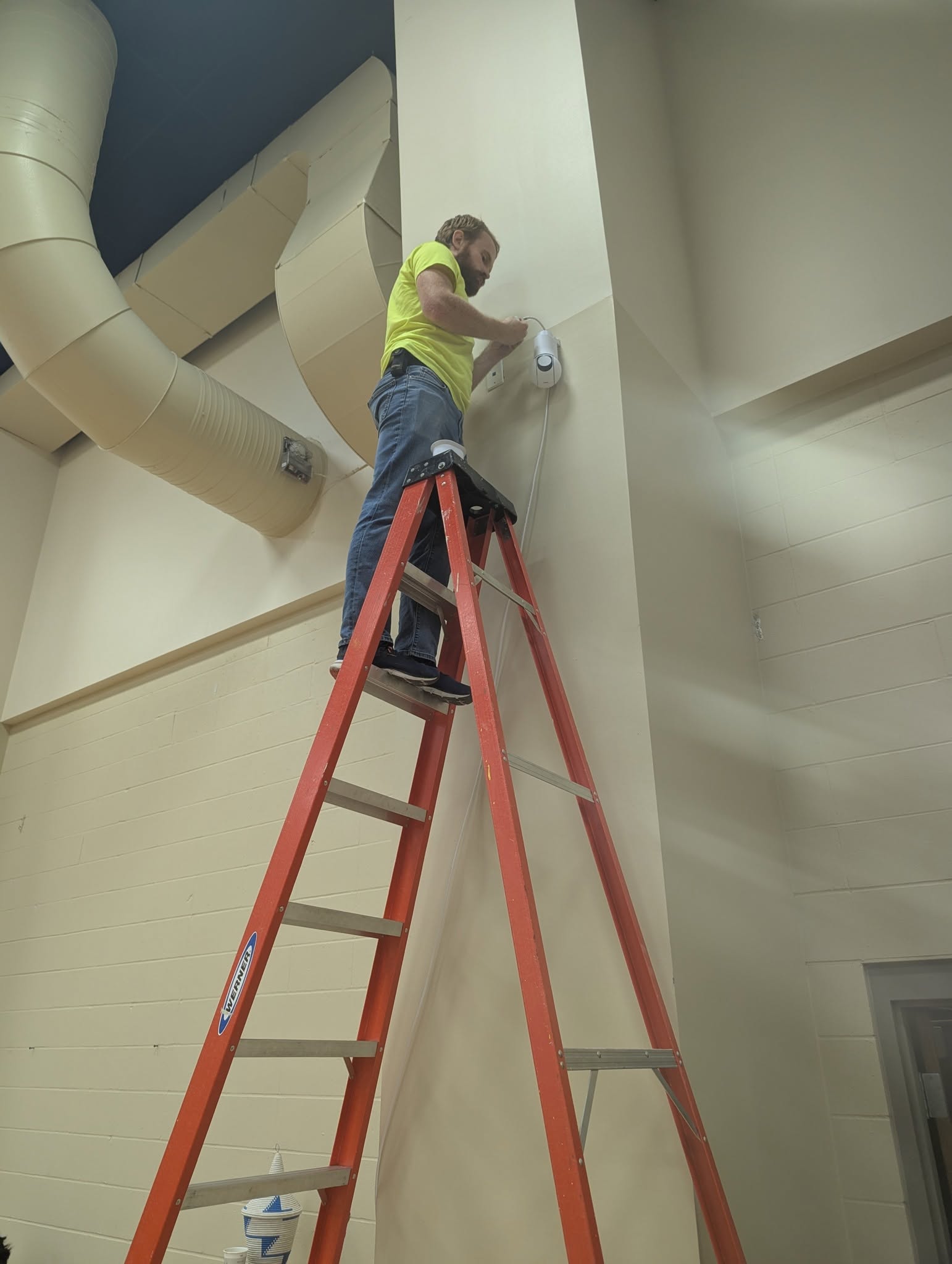 Technician installing wall-mounted network equipment